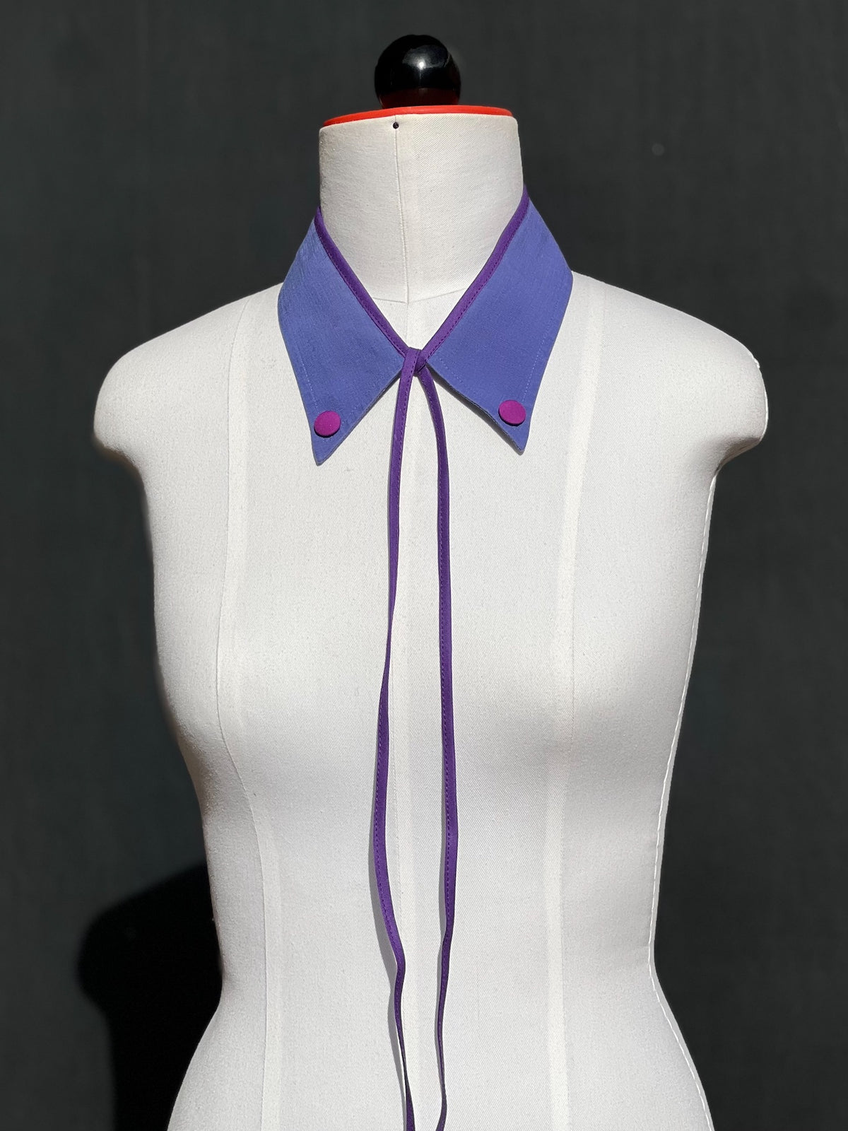 Kragencollier Periwinkle Pop in Lavendelblau mit Magenta-Knöpfen, violettes Band lang herabhängend