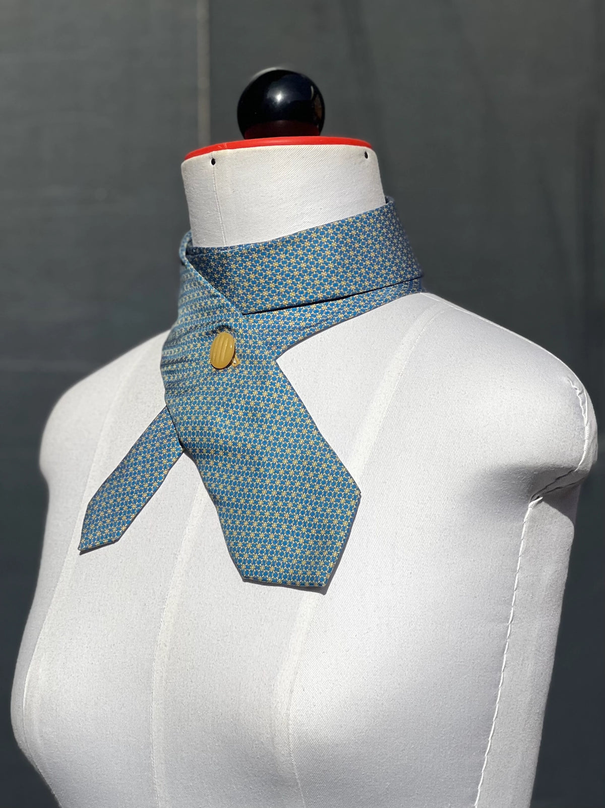 Schlipsschal Blue Dandy von der Seite, gelber gerillter Vintage-Knopf auf blauer Seide