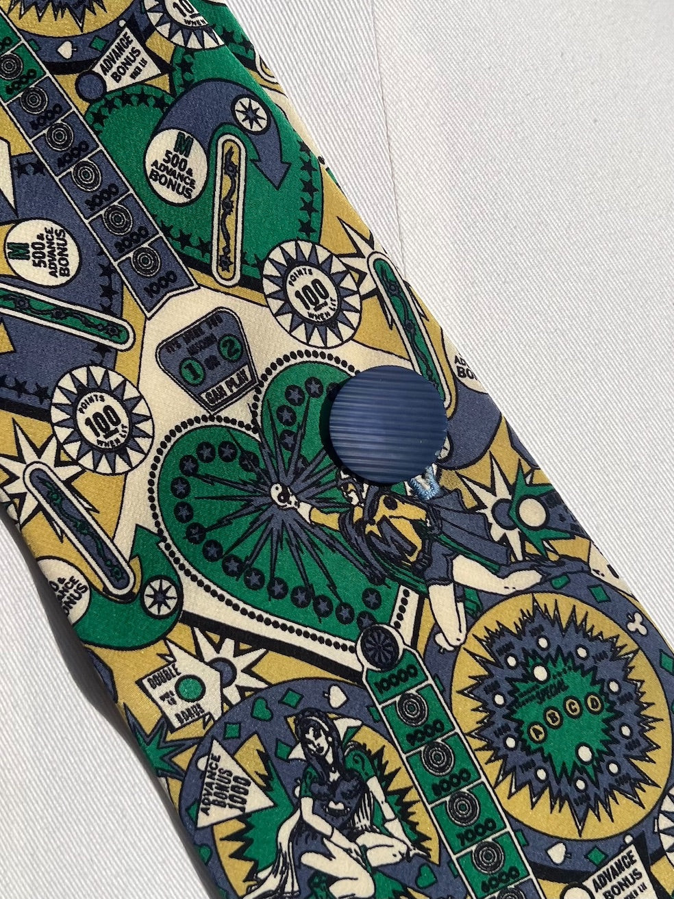 Detail: alter gerillter Knopf auf Seide mit Flipper-Motiv