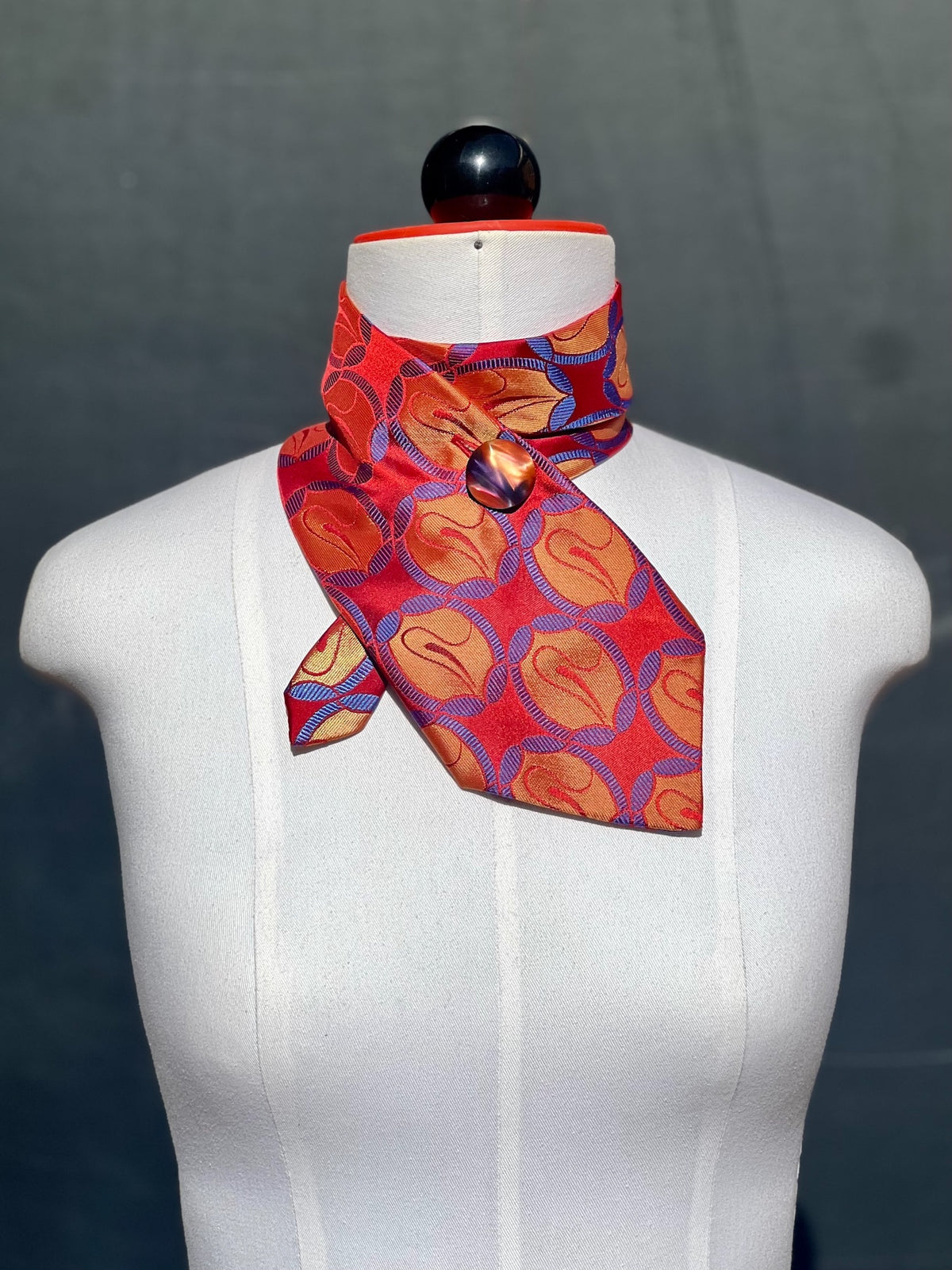 Schlipsschal Mandarin Mood mit orangefarbenen Ornamenten in violetten Ringen auf Rot, Frontansicht