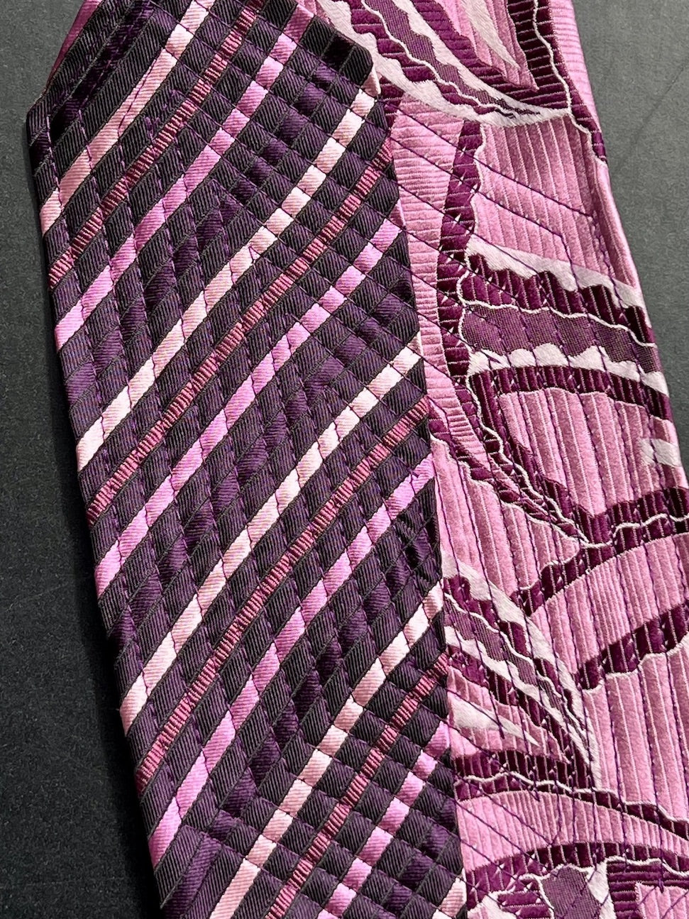 Detail: Steppnähte auf Streifen in Aubergine und Rosa neben Wellenmuster in Beere