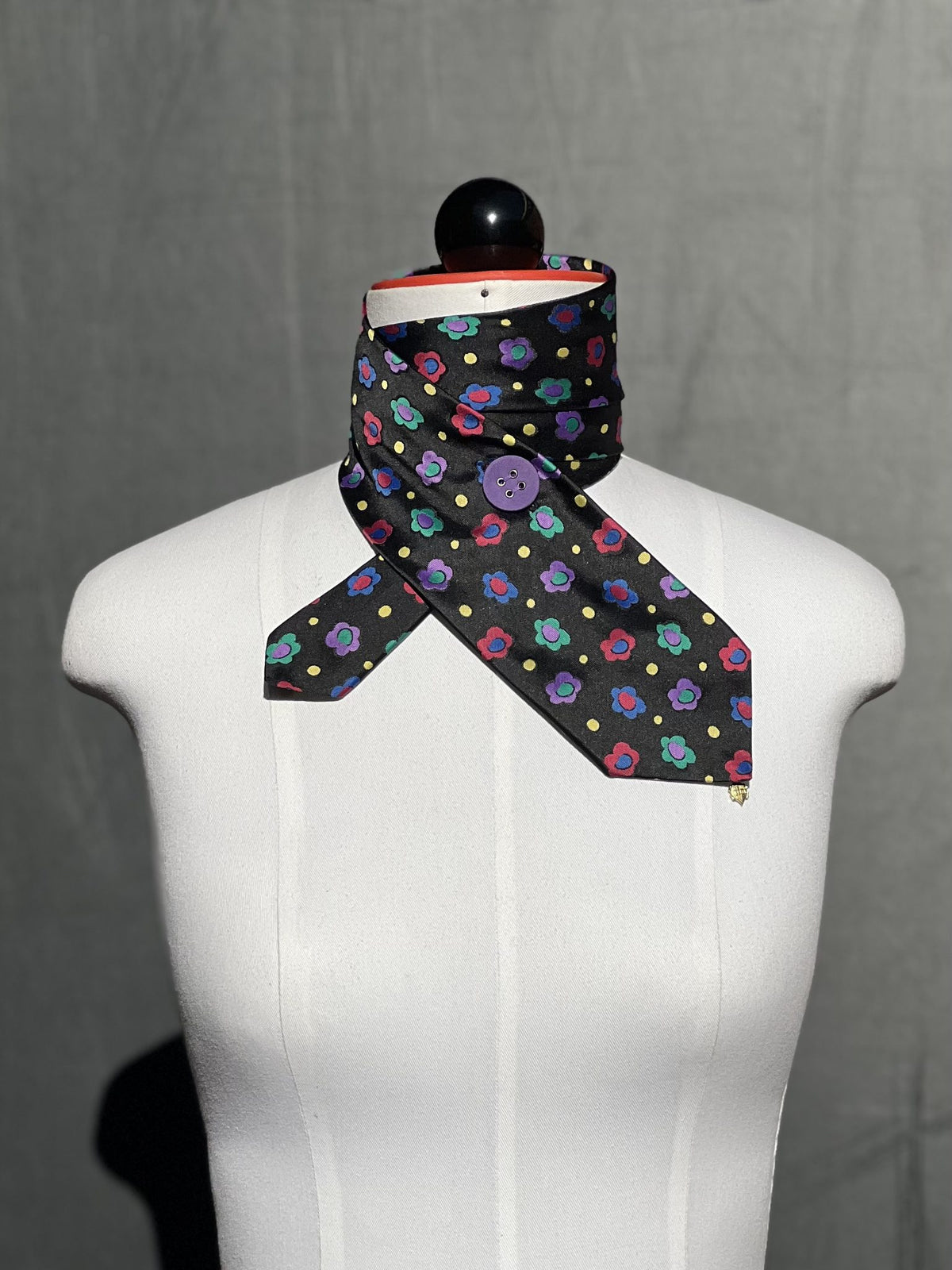 Schlipsschal Flower Pop in Schwarz mit bunten Blüten an der Schneiderpuppe, Frontansicht