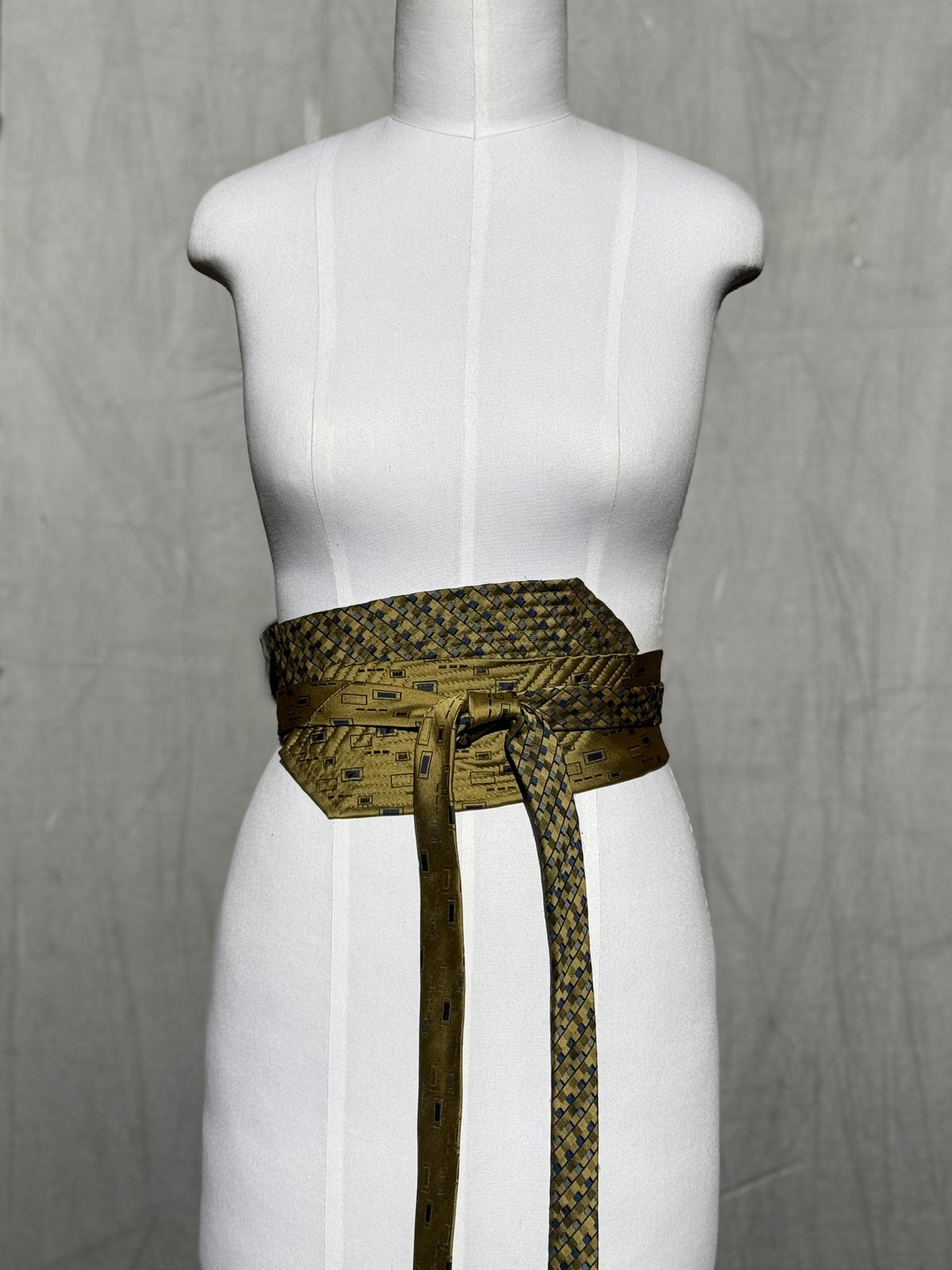 Obi-Gürtel Golden Weave in Oliv und Gold, vorne geknotet mit langen Enden, Frontansicht
