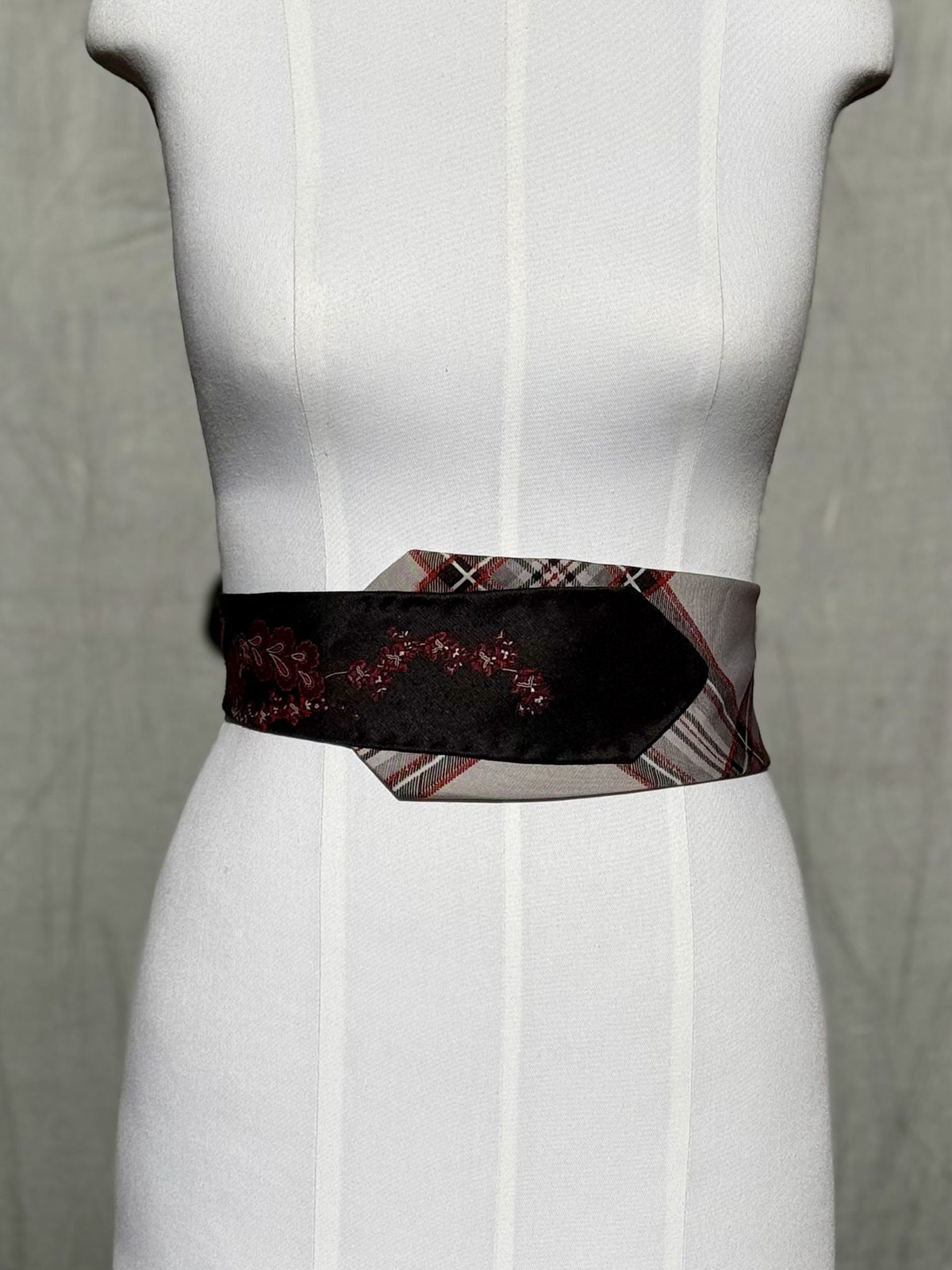 Obi-Gürtel Schottenball flach um die Taille gelegt, schwarzes Ornament mit Tartan-Spitze